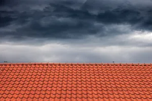 A red tile roof under a cloudy sky.