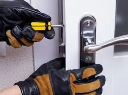 A person in black gloves is locking the door.