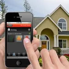 A person holding an iphone in front of a house.